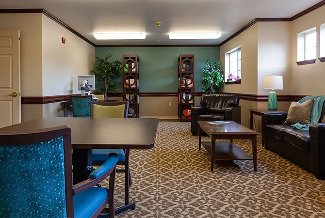 A cozy lounge area with seating, tables, and decorative plants.