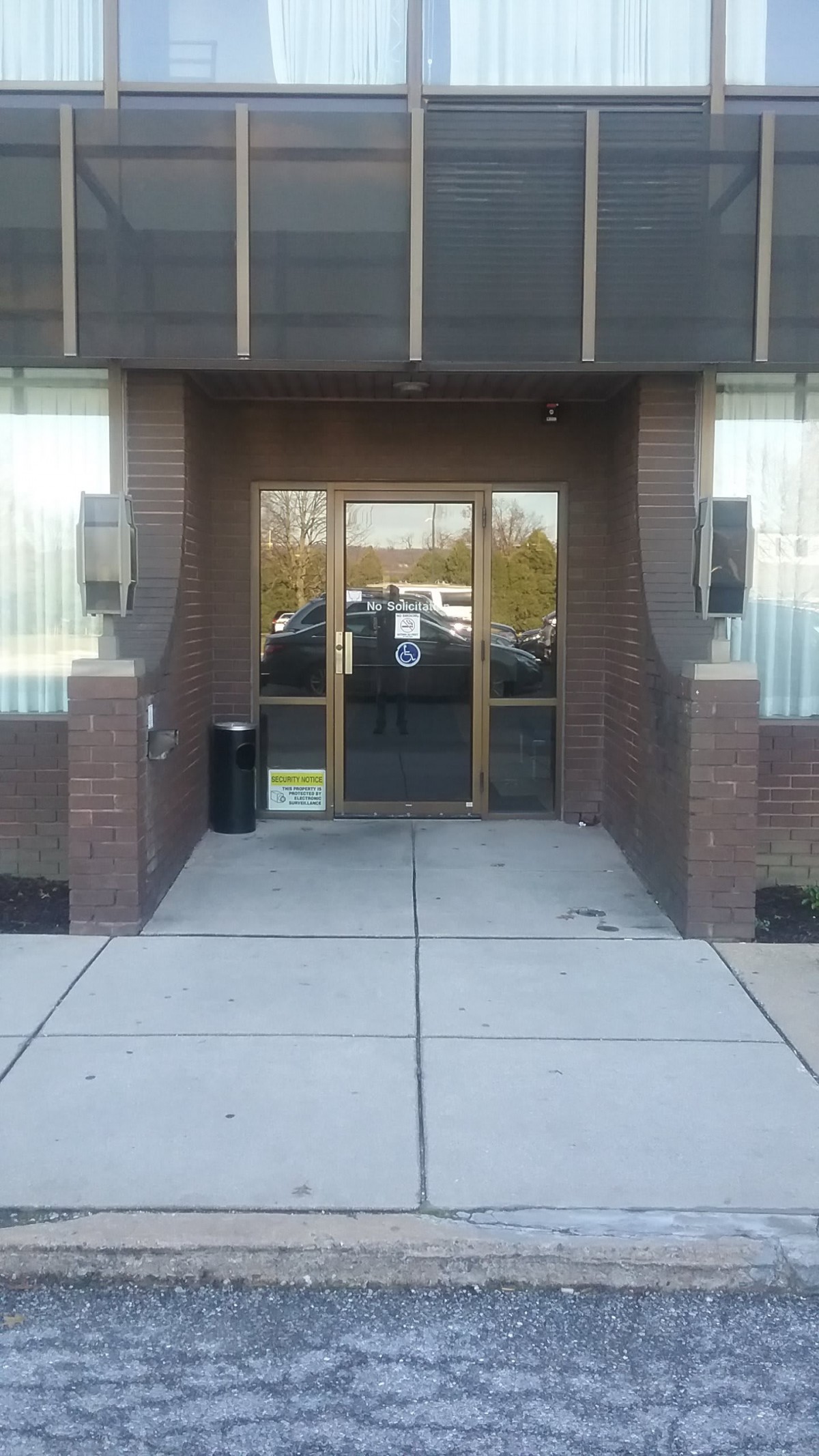 A building entrance with glass doors and brick walls.
