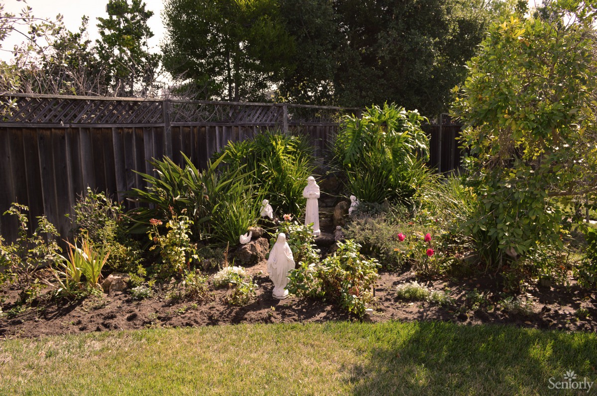 A beautifully landscaped garden with various plants and statues.