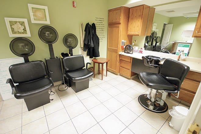 A cozy hair salon with seating, mirrors, and hair drying stations.