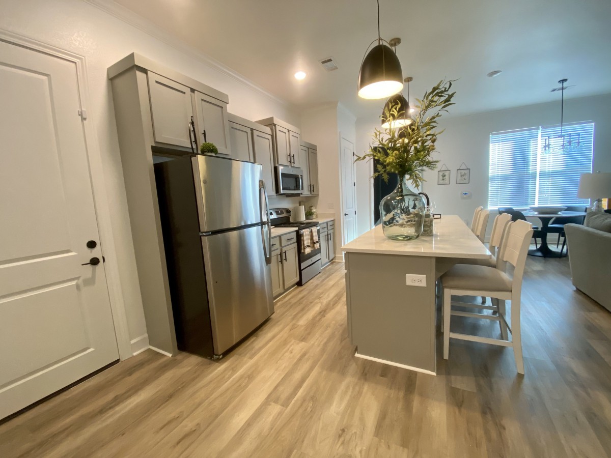 A modern kitchen with stainless steel appliances and a stylish island with bar stools.