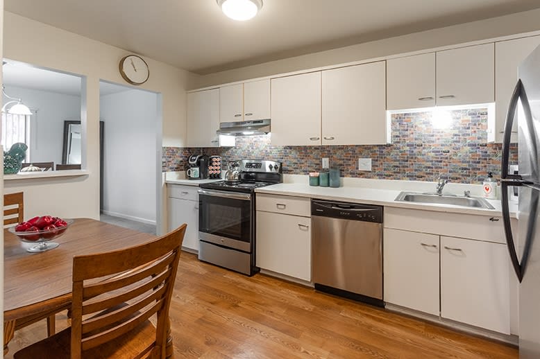 Modern kitchen with stainless steel appliances and hardwood flooring.