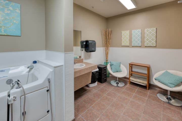 A modern and clean bathroom interior with a sink, chair, and washing machine.