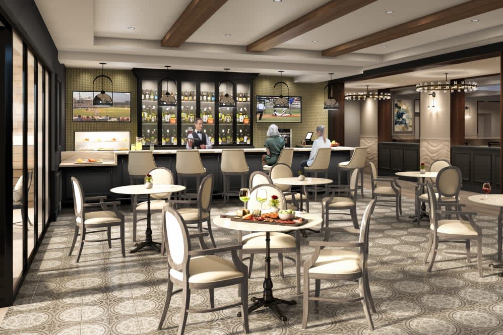 A cozy cafe interior with tables, chairs, and a bar area.