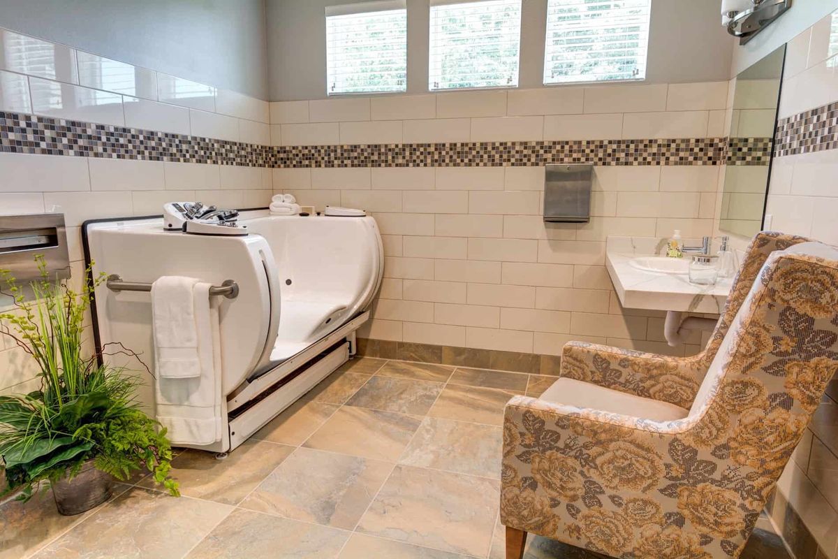An accessible bathroom featuring a walk-in tub and tiled walls, designed for comfort and ease of use.