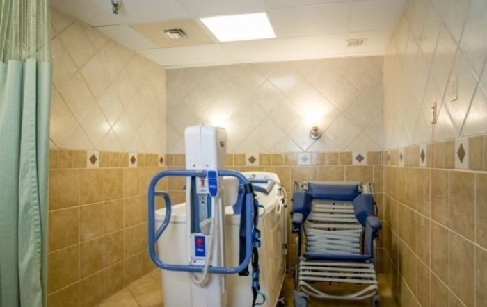 An accessible bathroom equipped with a shower chair and disability lift for easy bathing.