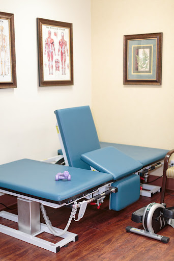 A well-equipped treatment room featuring therapy tables, suitable for various medical or rehabilitation therapies.