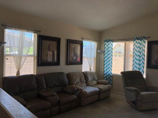 A cozy living room featuring comfortable seating and bright, airy windows.