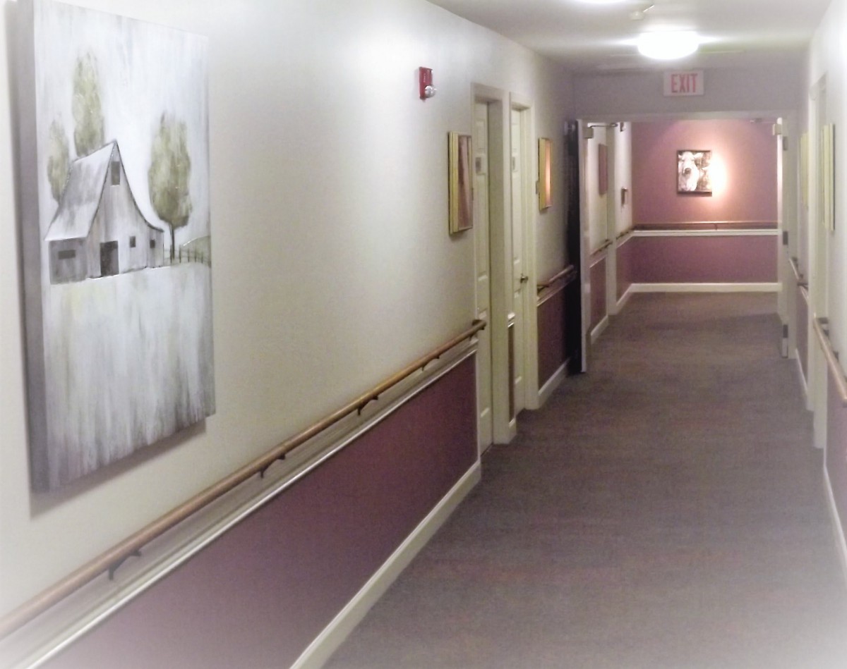 A well-lit hallway with paintings on the walls.