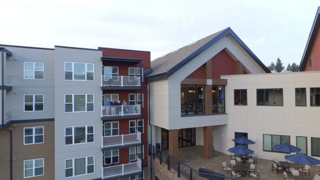 A modern residential apartment complex with a combination of large windows and balconies.