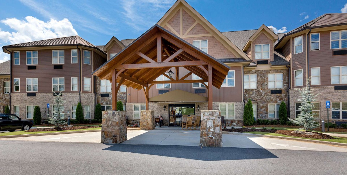 Entrance of a modern building with a wooden and stone covered walkway.