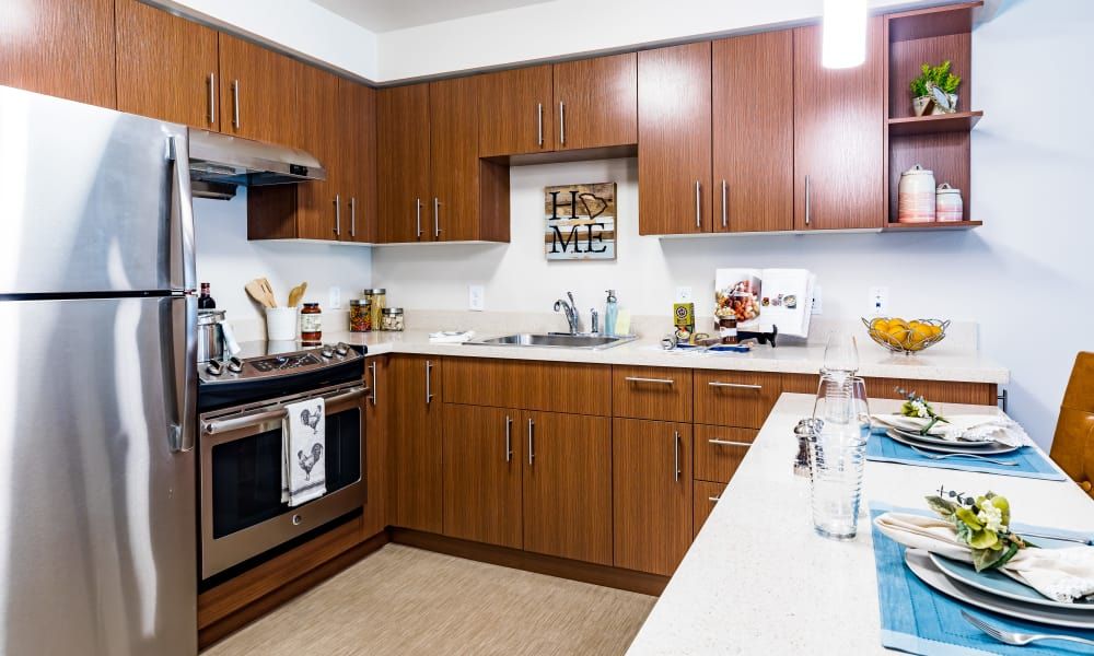 A modern kitchen with wooden cabinets and stainless steel appliances.