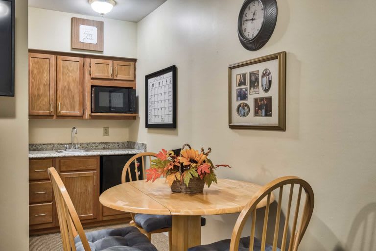 Cozy kitchen and dining area with a small round table, wall clock, and decor.