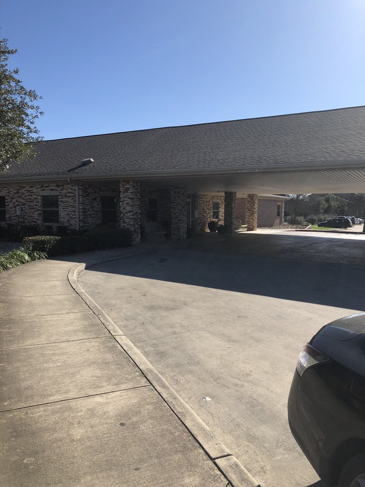 A driveway leading to the entrance of a building with a canopy.