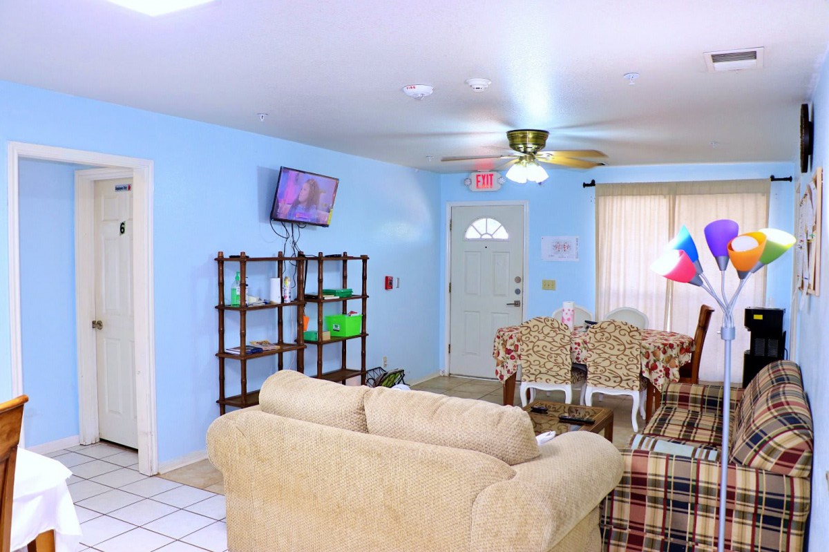 A cozy living room with blue walls, featuring a sofa, television, and other furniture.