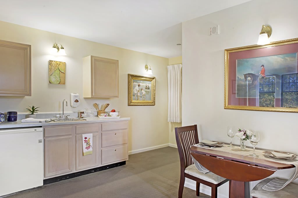 A modern kitchen and dining area with light-colored cabinets and elegant decor.