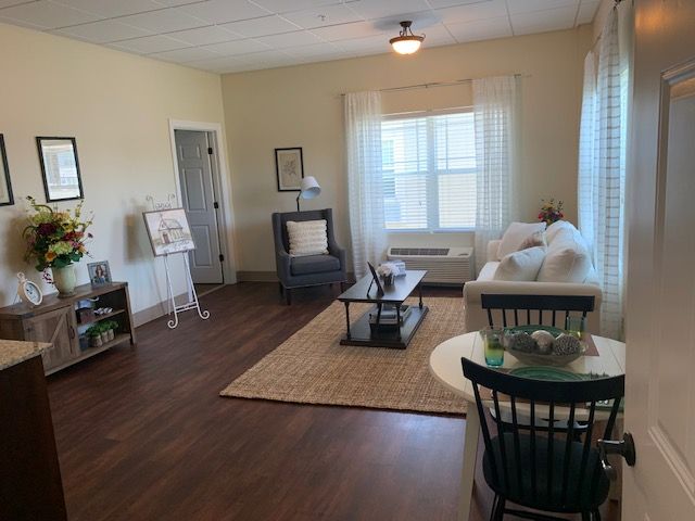 A cozy living room with a sofa, coffee table, and wooden floors.