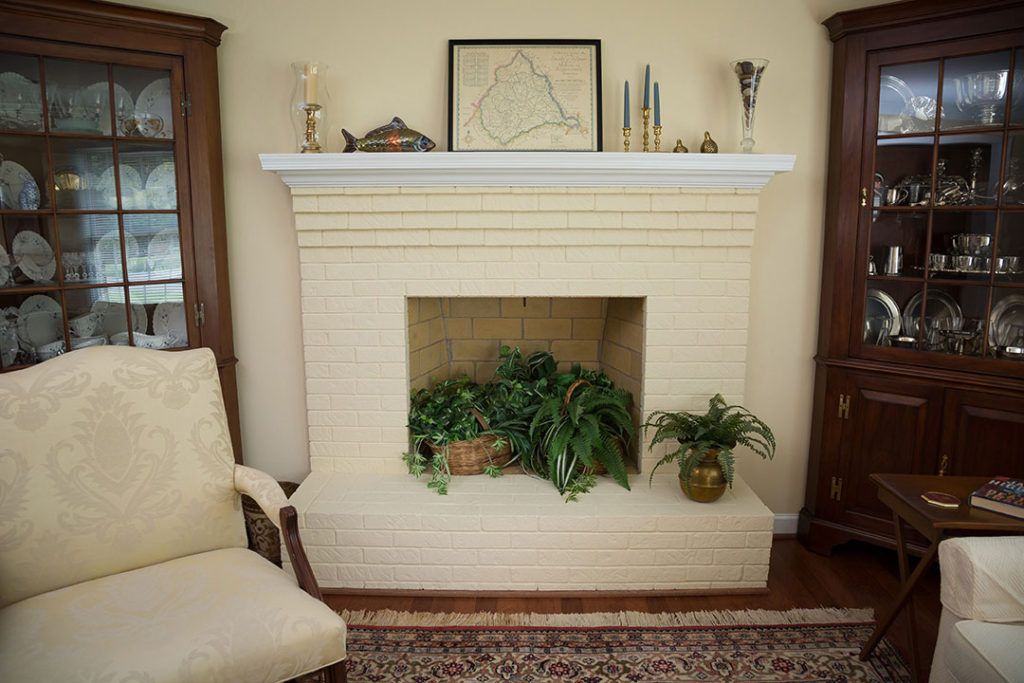 A cozy living room featuring a decorative fireplace adorned with plants and elegant decor.