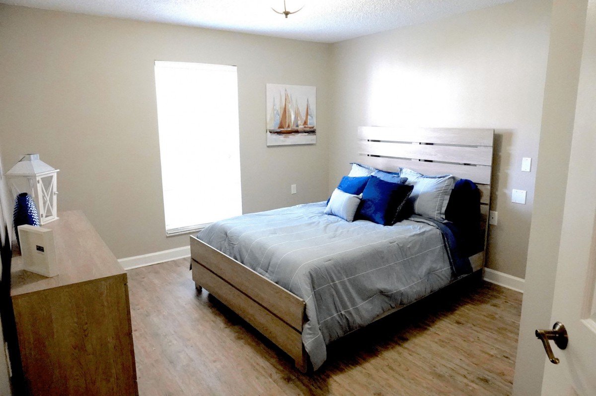 A bright, minimalistic bedroom with a bed and simple decor.