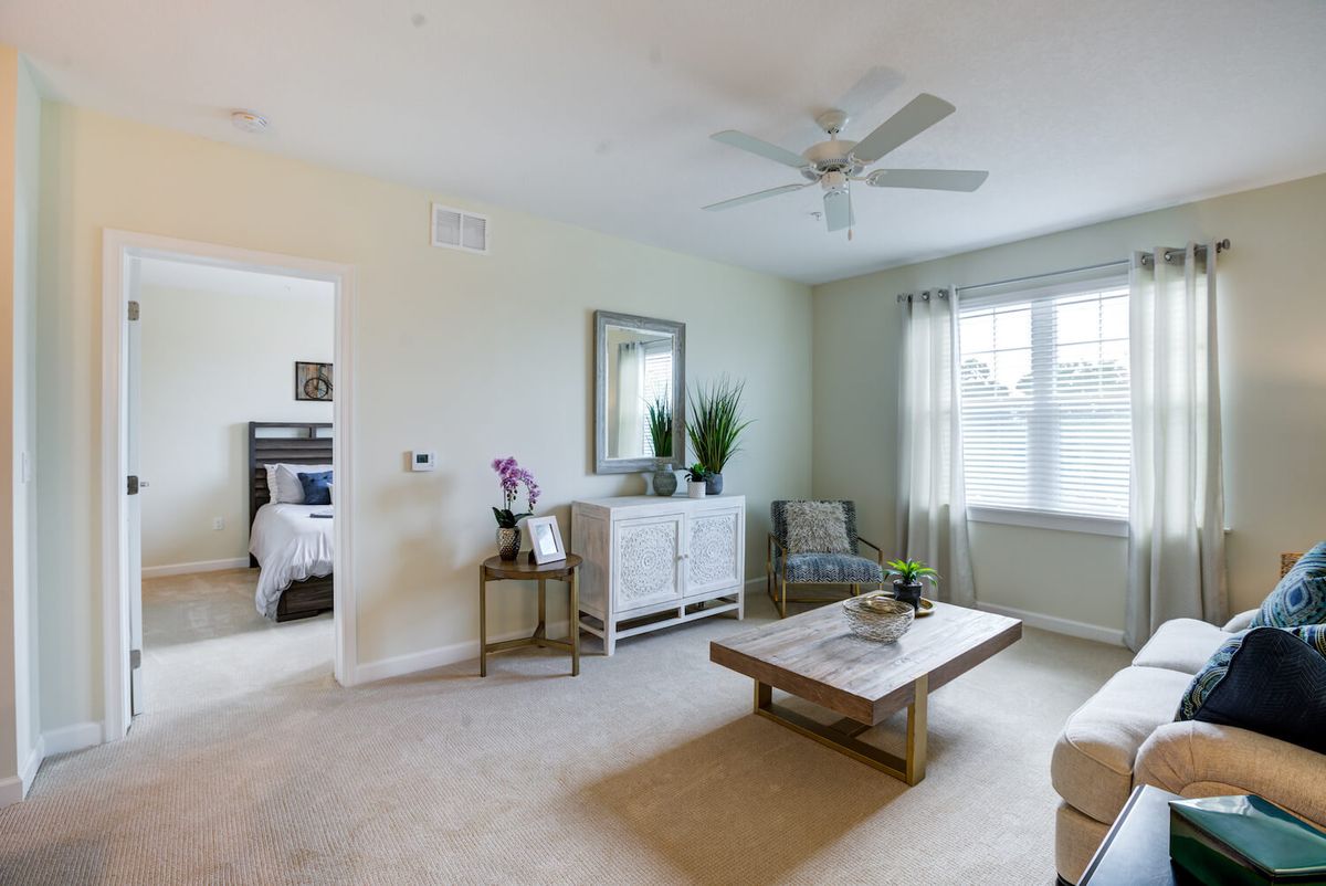 A modern living room with neutral tones, featuring a coffee table and comfortable seating.