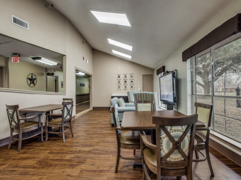 A modern living and dining area with skylights and wooden flooring.