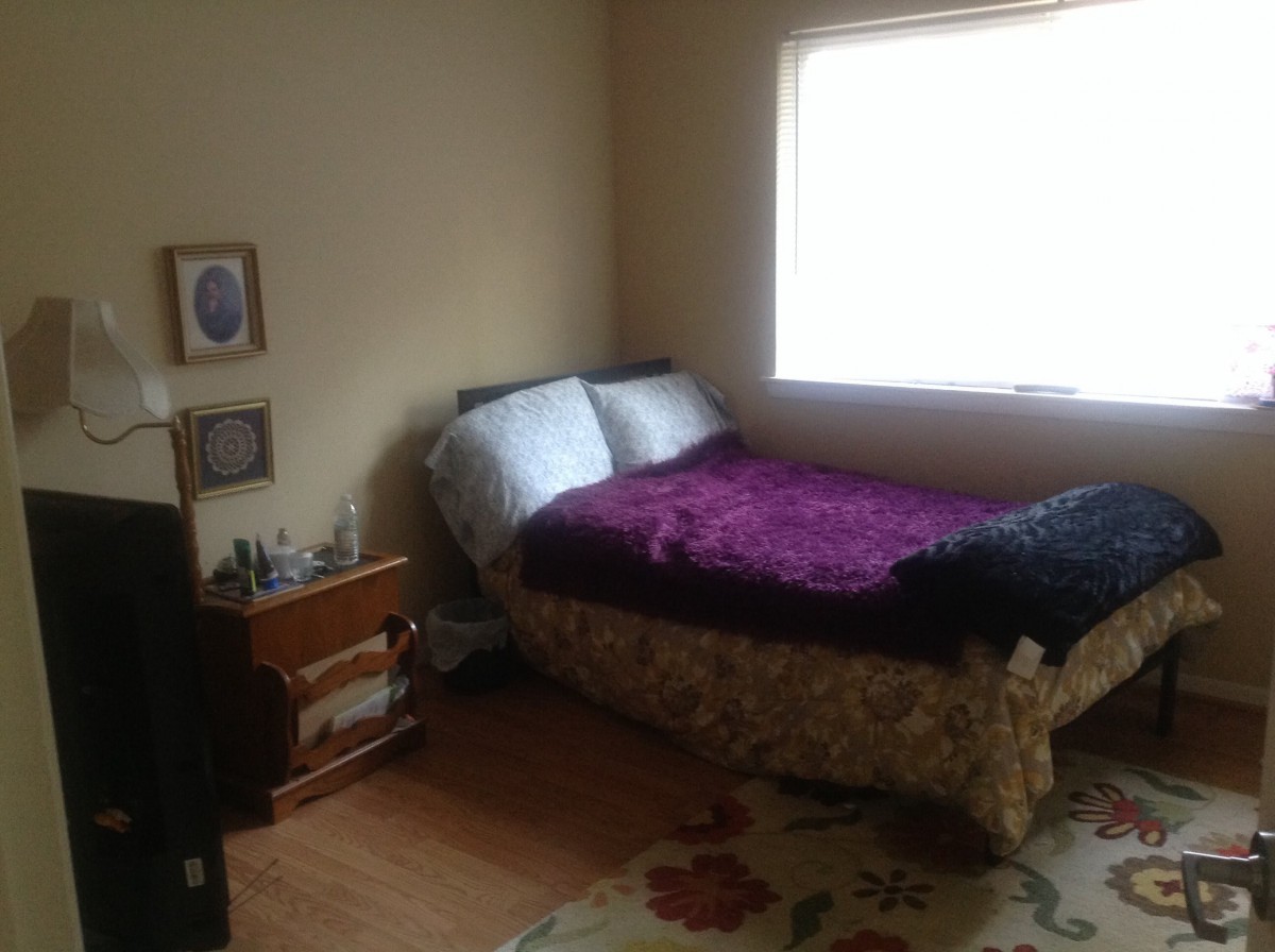 A cozy bedroom with a bed, nightstand, and window.