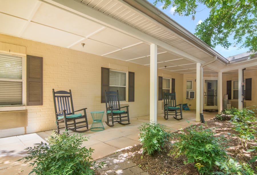 A cozy covered porch with rocking chairs and well-maintained landscaping.