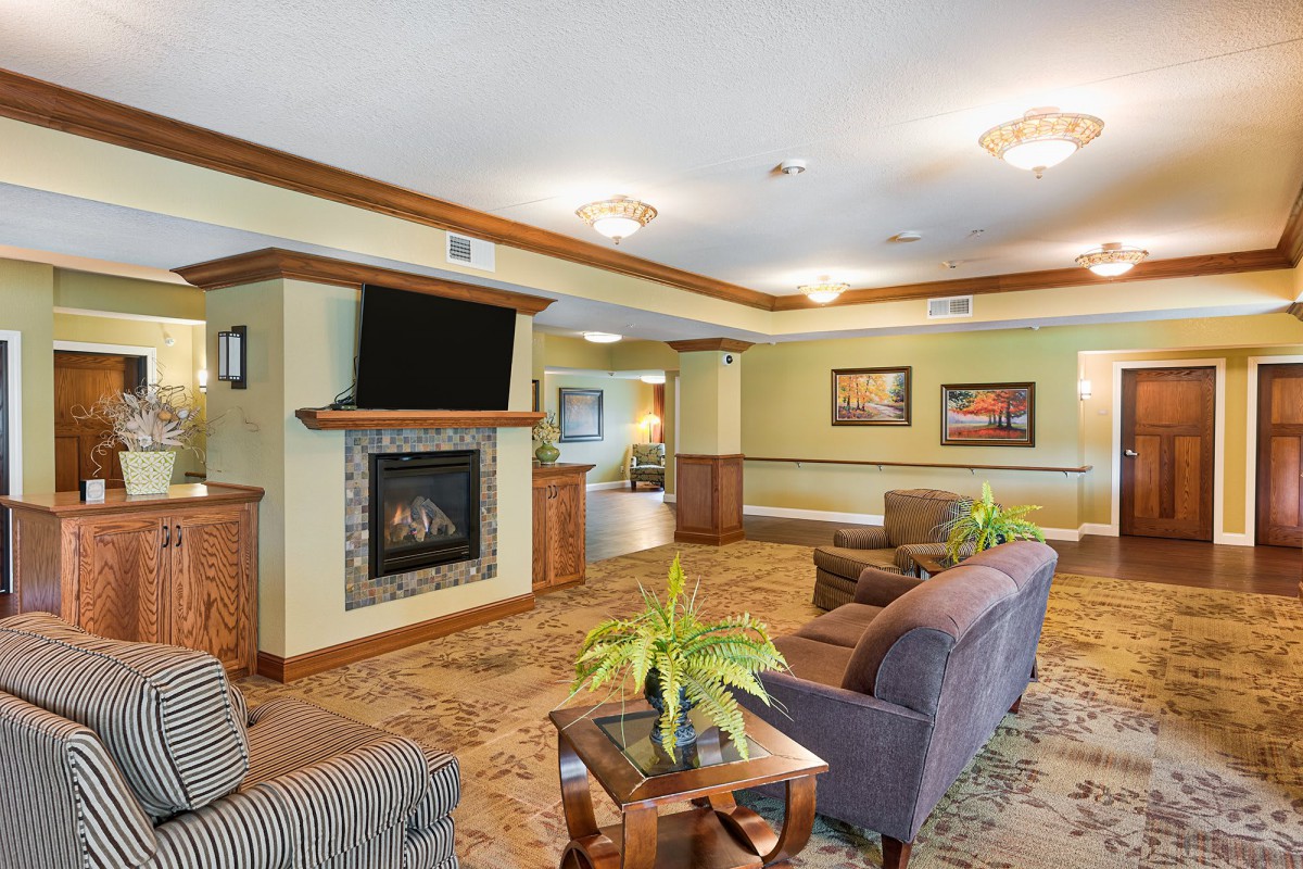 A cozy living room with a fireplace and television, featuring comfortable seating and elegant decor.