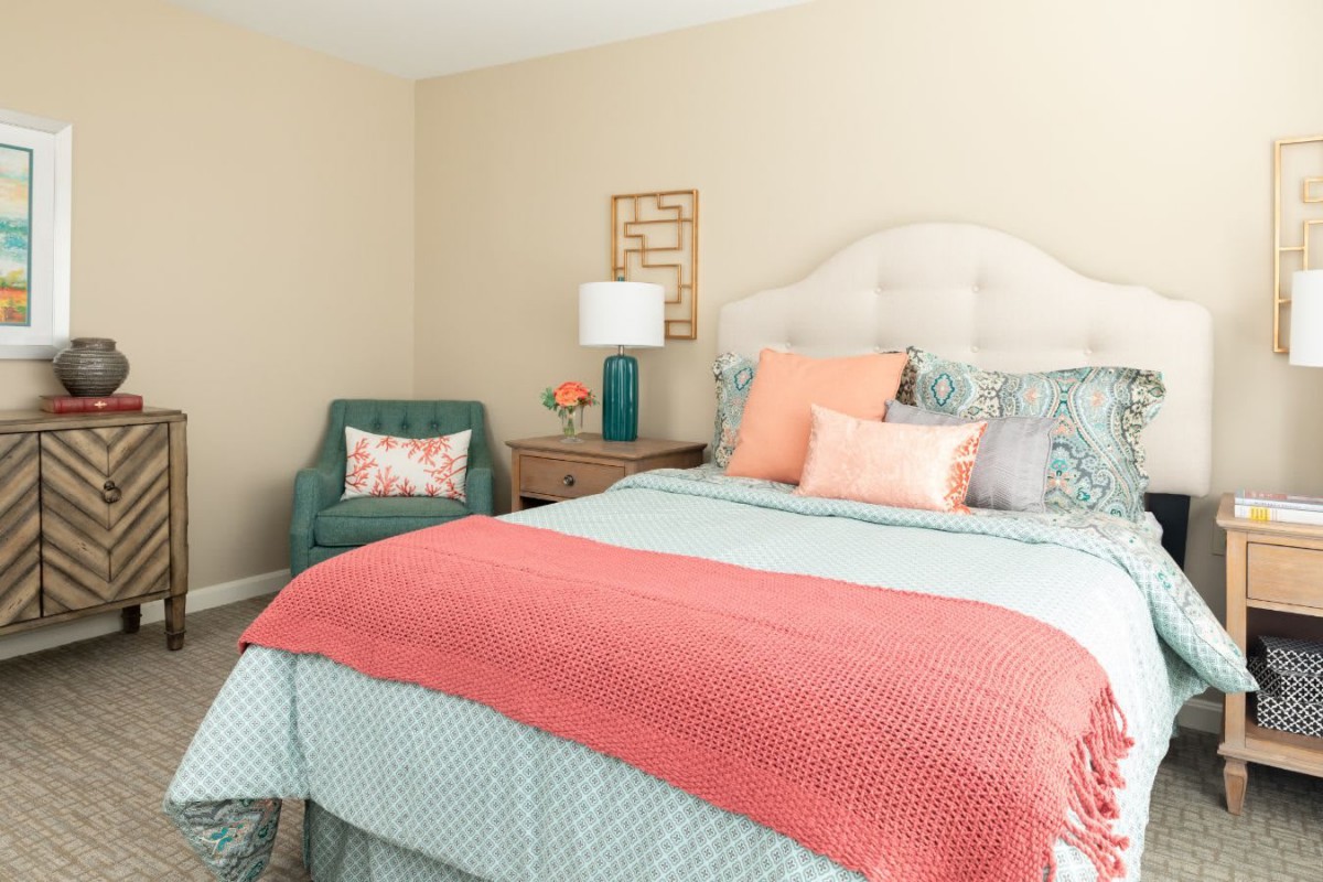 A cozy and stylish bedroom with a colorful bedspread and decorative pillows.
