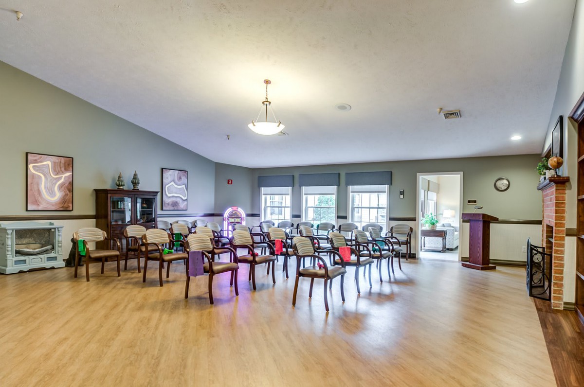 A spacious community room with arranged chairs and large windows, ideal for meetings or gatherings.