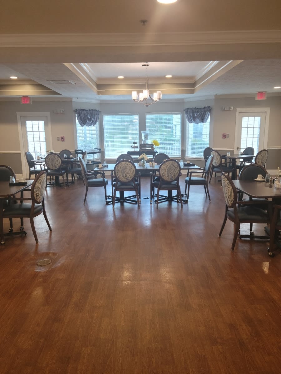 A spacious dining room with elegant furniture and large windows.