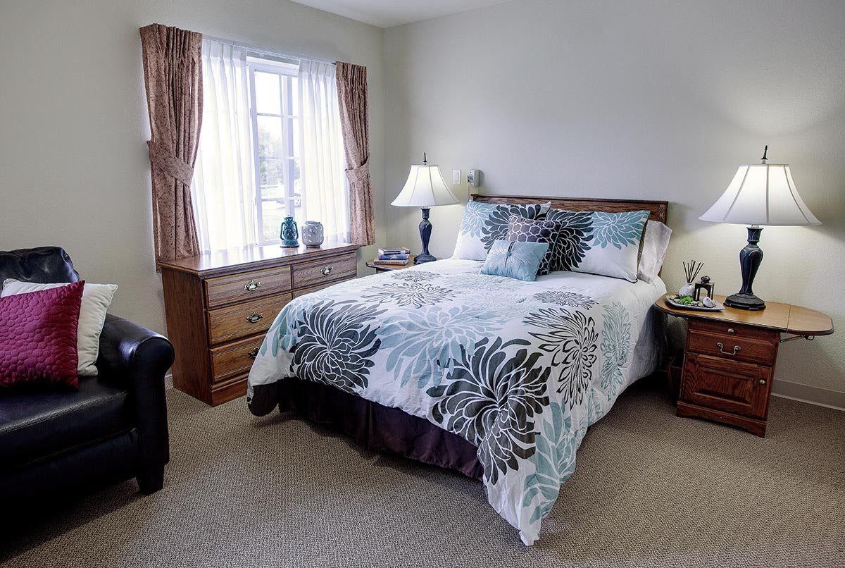A cozy bedroom with a neatly made bed, soft lighting, and elegant decor.