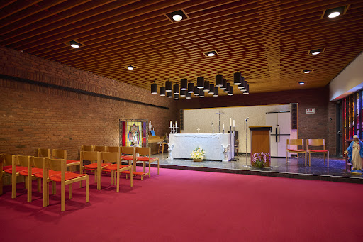 A serene interior view of a modern church chapel featuring an altar and seating.