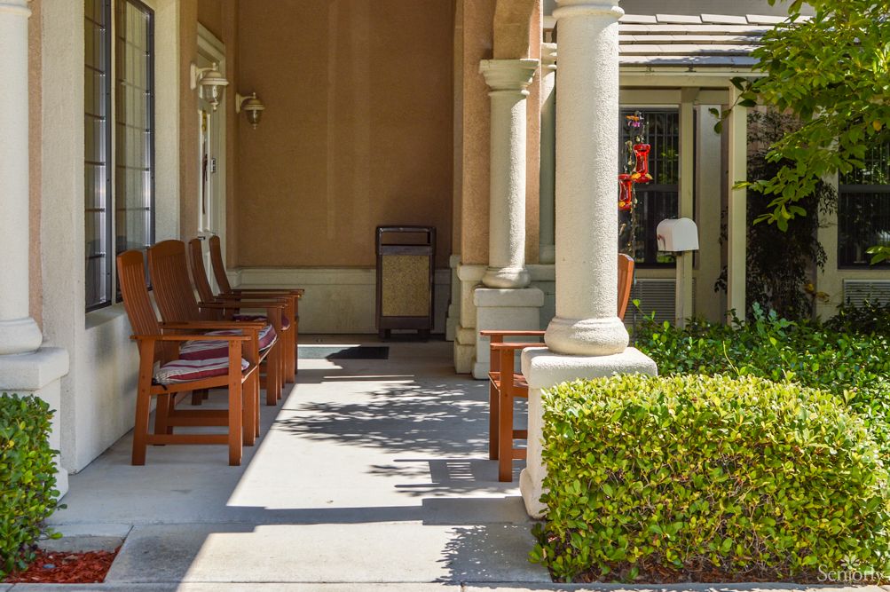 A tranquil outdoor seating area with benches and columns surrounded by greenery.