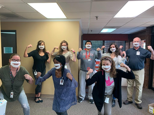 A fun day at the office as the team showcases their playful spirit with masks and poses.