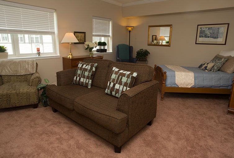 A cozy living room with a brown sofa, decorative pillows, and warm lighting.