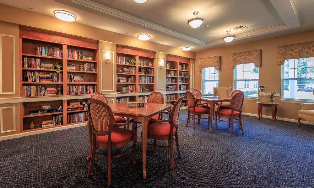A cozy library with bookshelves, tables, and chairs, perfect for reading or studying.