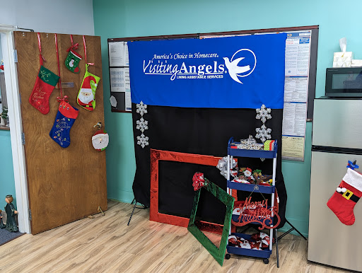 A festive setup featuring a Living Angels backdrop with holiday decorations, perfect for events and activities.