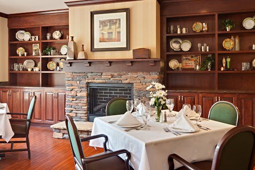 A beautifully set dining table in a cozy restaurant with a rustic fireplace and elegant decor.