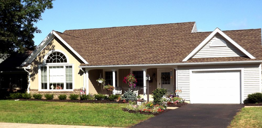 A single-story house with a well-maintained garden and a driveway.