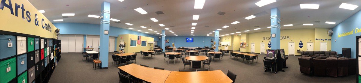 A spacious classroom with round tables and chairs arranged for group activities.