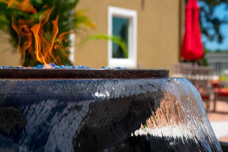 A close-up view of a decorative outdoor fountain with fire and water elements.