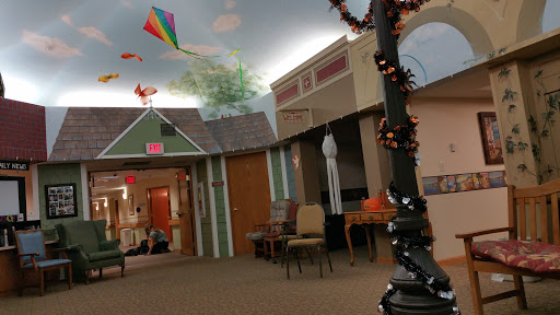A vibrant indoor community space adorned with kites and Halloween decorations, creating a lively atmosphere.