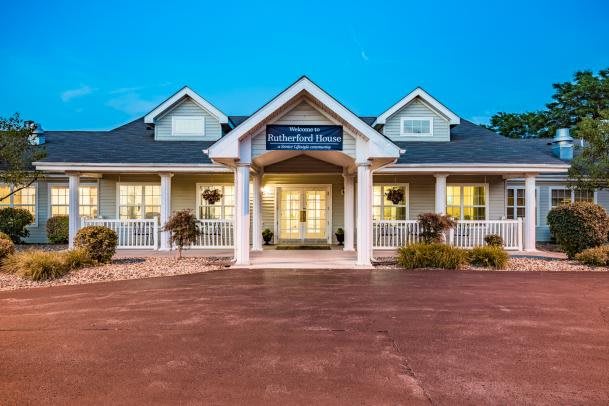 A charming residential house with a front porch and well-lit entrance.