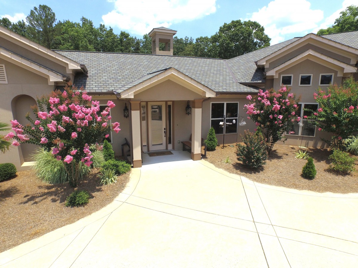 A welcoming house exterior with a landscaped garden and driveway.