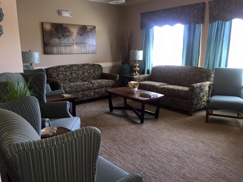 A cozy living room with two sofas, armchairs, and a coffee table.