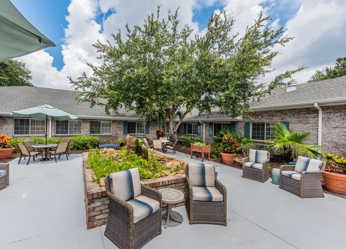 A well-furnished outdoor patio with comfortable seating and lush greenery.