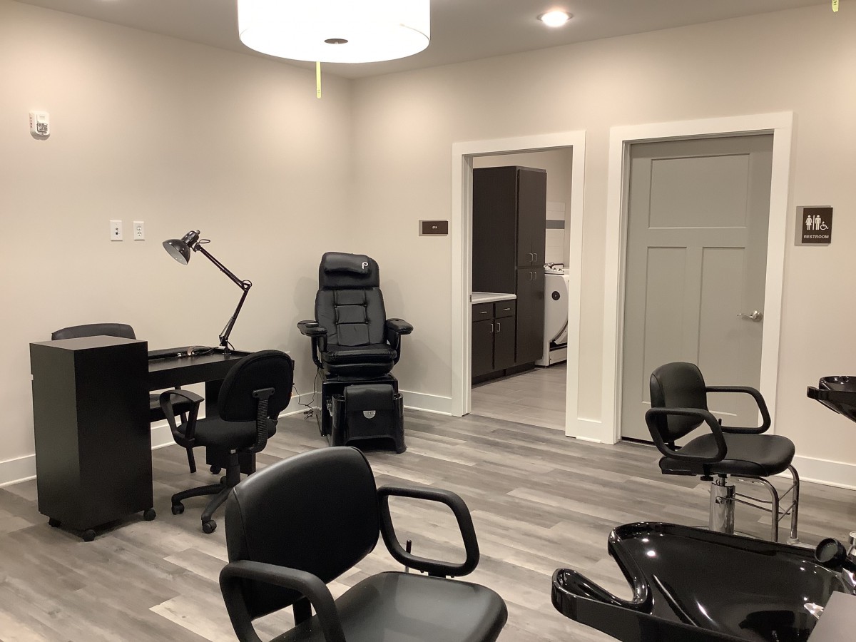 A modern salon interior featuring several chairs and workstations.
