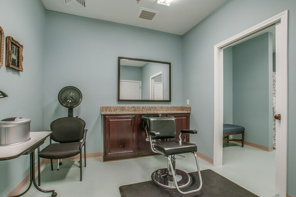 A modern salon interior with a barber chair, mirror, and hairdryer.