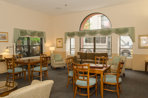 A cozy living space featuring wooden furniture and ample natural light.